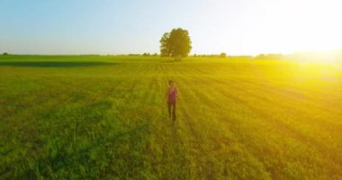 UHD 4k havadan görünümü. Alçak irtifa uçuş kırsal alan, sportif kadının önünde