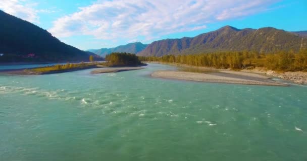 4k UHD航空ビュー。晴れた夏の朝に新鮮な冷たい山の川の上に低飛行。地平線の緑の木と太陽の光 — ストック動画