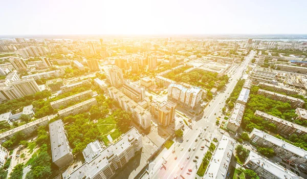 Vista aérea de la ciudad con encrucijadas y caminos, casas, edificios, parques y estacionamientos. Imagen panorámica soleada de verano — Foto de Stock