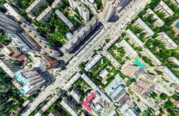 Vista aérea de la ciudad con encrucijadas y caminos, casas, edificios, parques y estacionamientos. Imagen panorámica soleada de verano — Foto de Stock