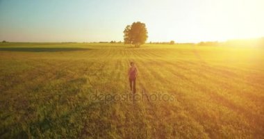 UHD 4k havadan görünümü. Alçak irtifa uçuş kırsal alan, sportif kadının önünde