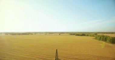 Yüksek voltajlı elektrik kulesi ve yeşil ve sarı alandaki elektrik hatları yakınında dikey hareket.