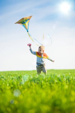 Genç çocuk onun uçurtma yeşil alan ile oynarken.