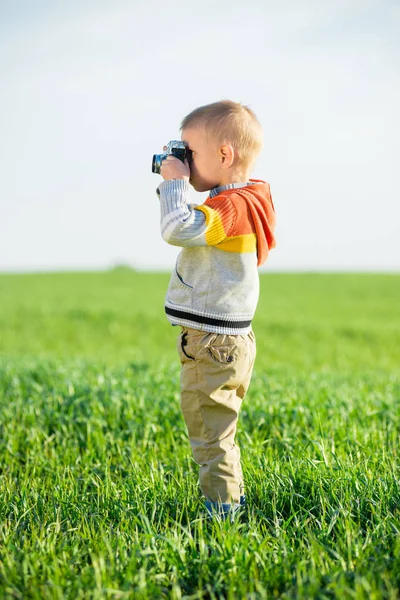 Маленький хлопчик зі старою знімальною камерою на вулиці . — стокове фото