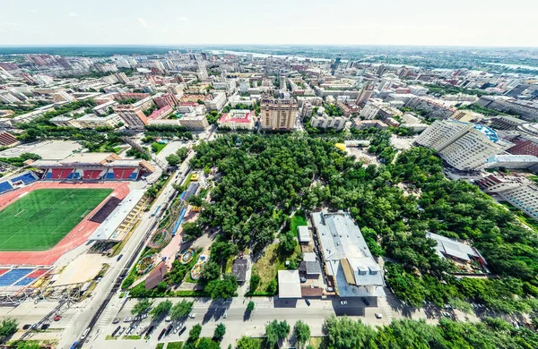 Vista aérea de la ciudad con encrucijadas y caminos, casas, edificios, parques y estacionamientos. Imagen panorámica soleada de verano — Foto de Stock