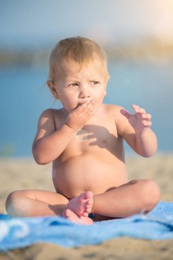 Şirin Bebek denize yakın kum plajındaki oyuncaklar ile oynama.