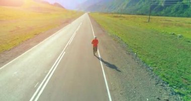 Mükemmel asfalt yolda sporcunun önünde alçak irtifa uçuşu.