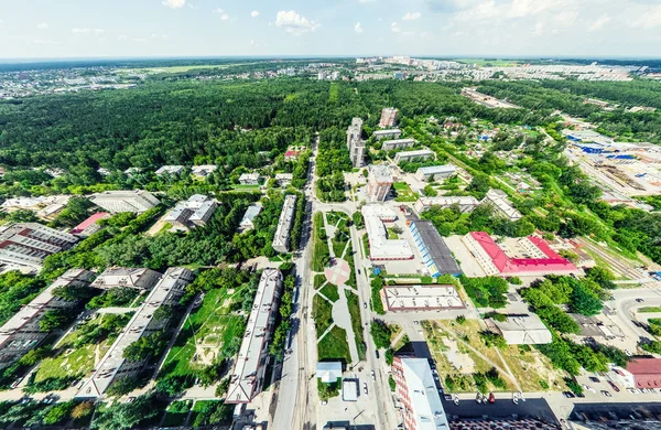 Vista aérea de la ciudad con encrucijadas y caminos, casas, edificios, parques y estacionamientos. Imagen panorámica soleada de verano — Foto de Stock