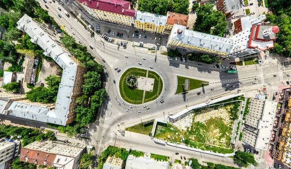 Vista aérea de la ciudad con encrucijadas y caminos, casas, edificios, parques y estacionamientos. Imagen panorámica soleada de verano —  Fotos de Stock