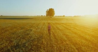 UHD 4k havadan görünümü. Alçak irtifa uçuş kırsal alan, sportif kadının önünde