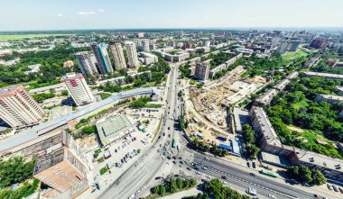 Kesişen yollar, evler, binalar, parklar ve otoparklar olan havacılık şehri manzarası. Güneşli yaz panoramik resmi