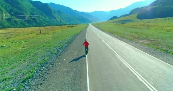 Vlucht van de lage hoogte achter van sportieve man op perfecte asfaltweg — Stockvideo