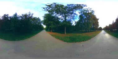 Bir şehir parkının UHD 4K 360 VR Sanal Gerçekliği. Sonbaharda ya da yaz gününde ağaçlar ve yeşil çimenler
