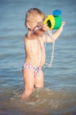 Şirin Bebek kumlu plajı ve deniz suyu oynarken.