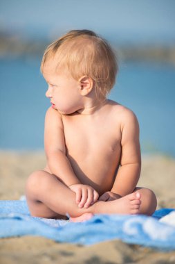 Şirin Bebek denize yakın kum plajındaki oyuncaklar ile oynama.