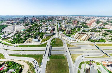 Kesişen yollar, evler, binalar, parklar ve otoparklar olan havacılık şehri manzarası. Güneşli yaz panoramik resmi