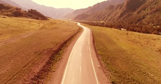 Vuelo sobre carretera asfaltada montaña carretera y prado — Vídeos de Stock