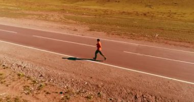 Mükemmel asfalt yolda sporcunun önünde alçak irtifa uçuşu.