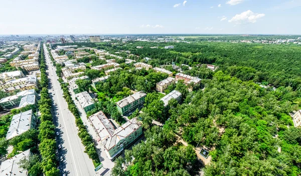 Vista aérea de la ciudad con encrucijadas y caminos, casas, edificios, parques y estacionamientos. Imagen panorámica soleada de verano — Foto de Stock