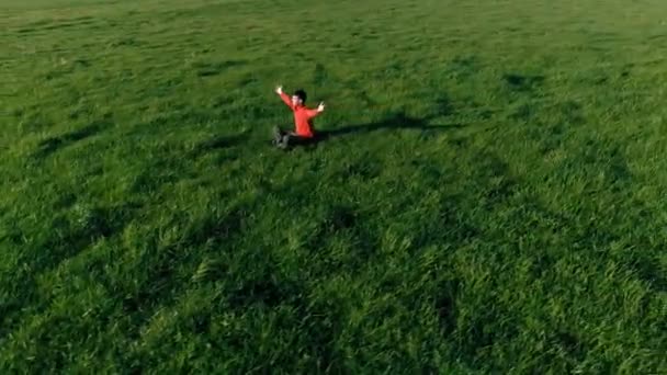 Vôo radial de baixa altitude sobre homem de ioga esporte na grama verde perfeita. Pôr do sol na montanha. — Vídeo de Stock