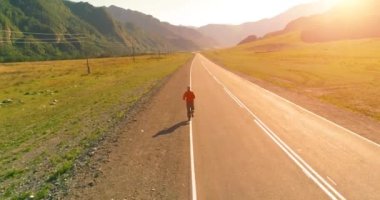 Mükemmel asfalt yol, sportif adamın arkasında alçak irtifa uçuş