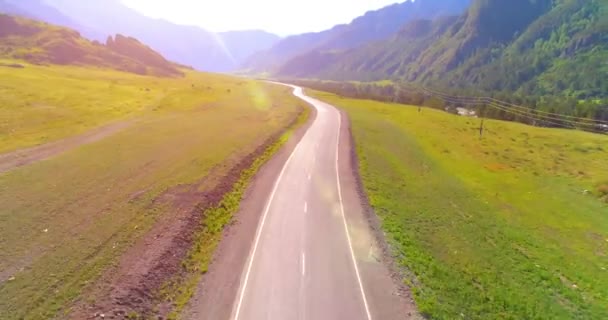 Vuelo sobre carretera asfaltada montaña carretera y prado — Vídeo de stock