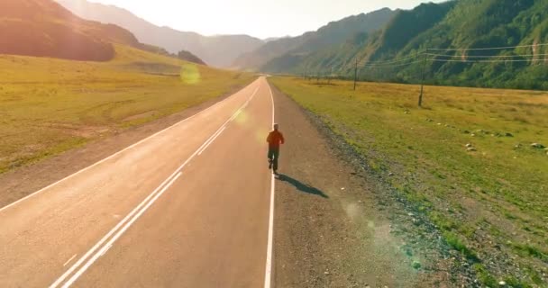 Mükemmel asfalt yol, sportif adamın arkasında alçak irtifa uçuş — Stok video