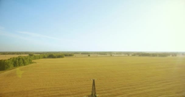 Вертикальный полет вблизи башни высокого напряжения и линий электропередач на зеленом и желтом полях — стоковое видео