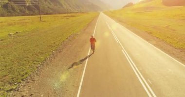 Mükemmel asfalt yolda sporcunun önünde alçak irtifa uçuşu.