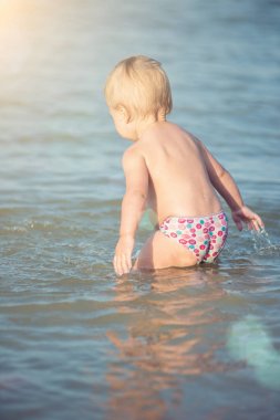 Şirin Bebek kumlu plajı ve deniz suyu oynarken.