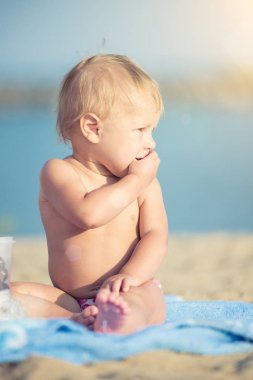 Şirin Bebek denize yakın kum plajındaki oyuncaklar ile oynama.