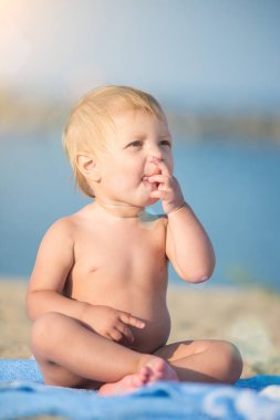 Şirin Bebek denize yakın kum plajındaki oyuncaklar ile oynama.