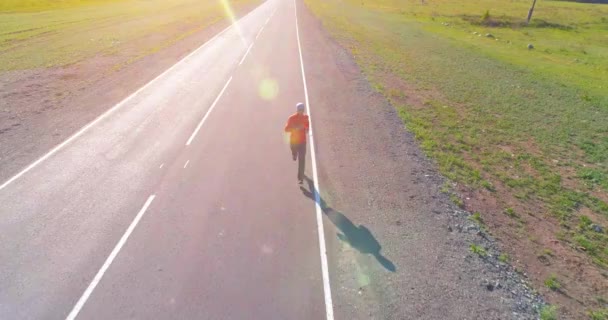 Volo a bassa quota di fronte all'uomo sportivo in perfetta strada asfaltata — Video Stock