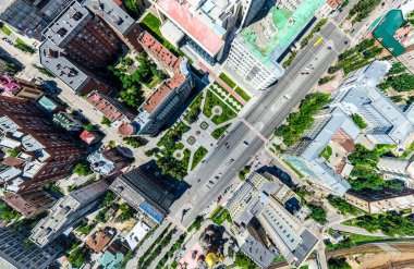 Kesişen yollar, evler, binalar, parklar ve otoparklar olan havacılık şehri manzarası. Güneşli yaz panoramik resmi