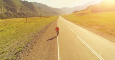 Mükemmel asfalt yol, sportif adamın arkasında alçak irtifa uçuş
