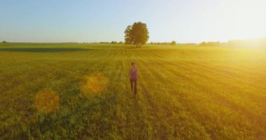 UHD 4k havadan görünümü. Alçak irtifa uçuş kırsal alan, sportif kadının önünde