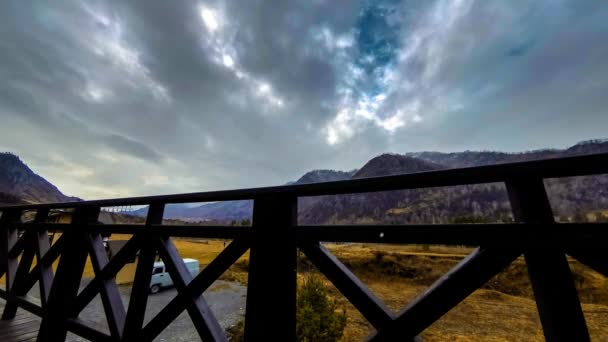 Timelapse του ξύλινου φράχτη στην ψηλή βεράντα στο ορεινό τοπίο με σύννεφα. Οριζόντια κίνηση κύλισης — Αρχείο Βίντεο