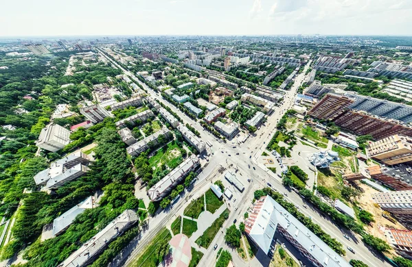 Vista aérea de la ciudad con encrucijadas y caminos, casas, edificios, parques y estacionamientos. Imagen panorámica soleada de verano —  Fotos de Stock