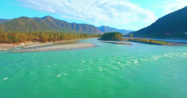 4k UHD aerial view. Low flight over fresh cold mountain river at sunny summer morning. Green trees and sun rays on horisont — Stock Video