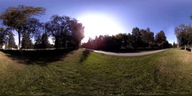 Bir şehir parkının UHD 4K 360 VR Sanal Gerçekliği. Sonbaharda ya da yaz gününde ağaçlar ve yeşil çimenler
