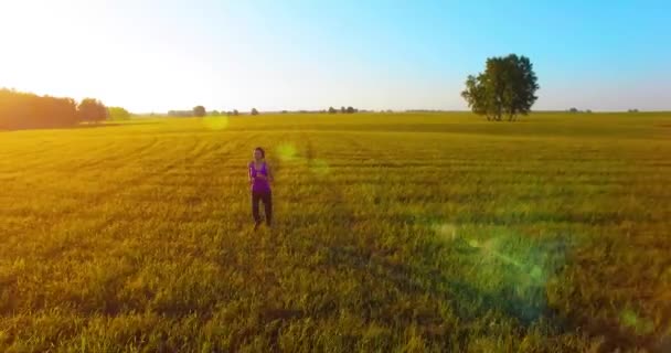 Voo de drone de baixa altitude na frente de uma mulher esportiva na estrada de asfalto perfeita — Vídeo de Stock