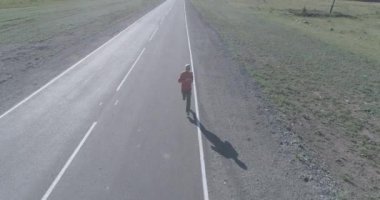 Mükemmel asfalt yolda sporcunun önünde alçak irtifa uçuşu.