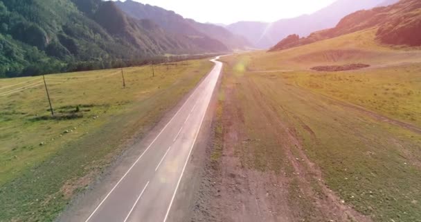 Flight over mountain asphalt highway road and meadow — Stock Video