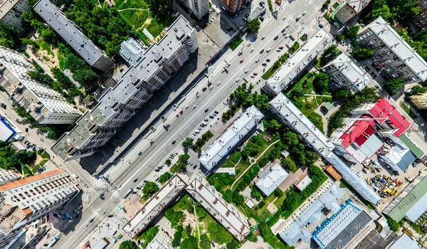 Aerial city view with crossroads and roads, houses, buildings, parks and parking lots. Sunny summer panoramic image — Stock Photo, Image