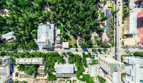 Uitzicht op de stad vanuit de lucht met kruispunten en wegen, huizen, gebouwen, parken en parkeerplaatsen. Zonnige zomer panoramisch beeld — Stockfoto