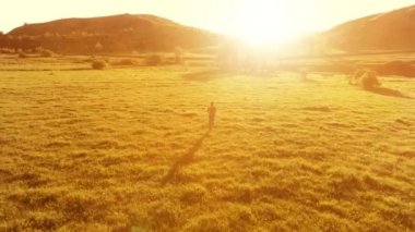 Mükemmel yeşil çayır üzerinde uçan bir sporcu. Dağda gün batımı