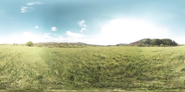 360 VR a unei frumoase pajiști montane în timpul verii sau toamnei. Nori, iarbă verde și raze de soare . — Videoclip de stoc