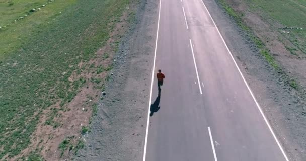 Vôo de baixa altitude sobre homem desportivo em nova estrada de asfalto — Vídeo de Stock