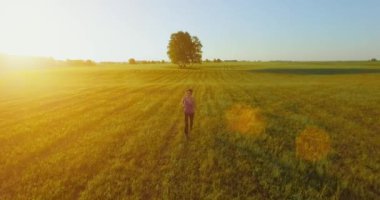 UHD 4k havadan görünümü. Alçak irtifa uçuş kırsal alan, sportif kadının önünde