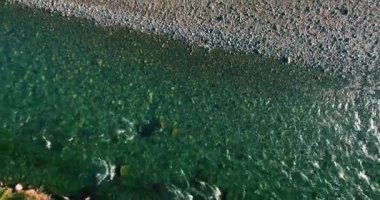 Güneşli yaz sabahında kayalarla birlikte taze, hızlı dağ nehri üzerinde alçak irtifa uçuşu..